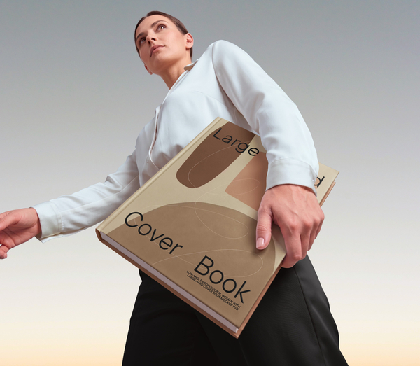 Low-Angle Professional Woman with Large Hard Cover Book Mockup PSD
