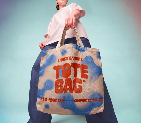 Model Holding Large Natural Canvas Tote Bag PSD Mockup
